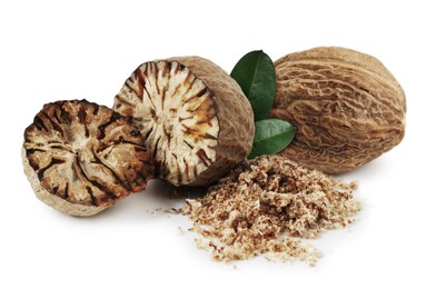 Image of Nutmeg seeds with green leaves on white background. Aromatic spice