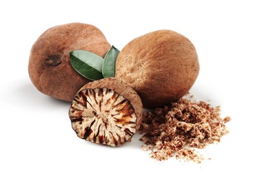 Image of Nutmeg seeds with green leaves on white background. Aromatic spice