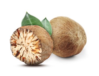 Image of Nutmeg seeds with green leaves on white background. Aromatic spice