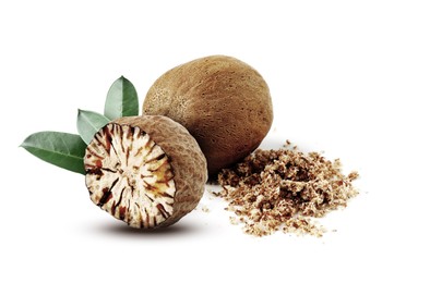 Image of Nutmeg seeds with green leaves on white background. Aromatic spice
