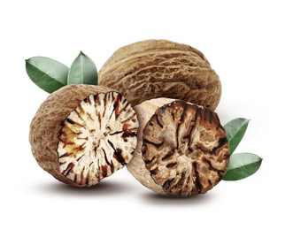 Image of Nutmeg seeds with green leaves on white background. Aromatic spice