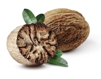 Image of Nutmeg seeds with green leaves on white background. Aromatic spice