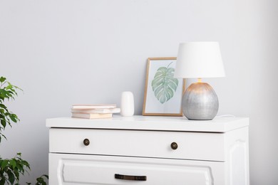 Photo of Different decor on white chest of drawers indoors