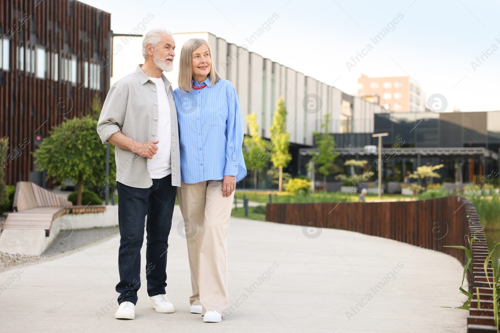 Lovely senior couple walking together on city street, space for text Photo of Lovely senior couple walking together on city street, space for text