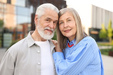 Photo of Lovely senior couple walking together on city street
