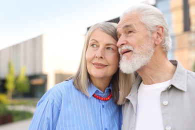 Photo of Lovely senior couple walking together on city street