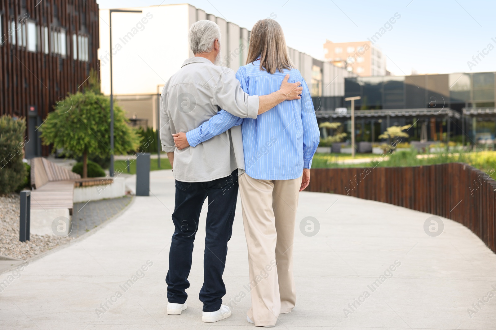 Lovely senior couple walking together on city street, back view Photo of Lovely senior couple walking together on city street, back view