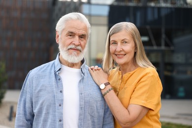 Photo of Lovely senior couple walking together on city street