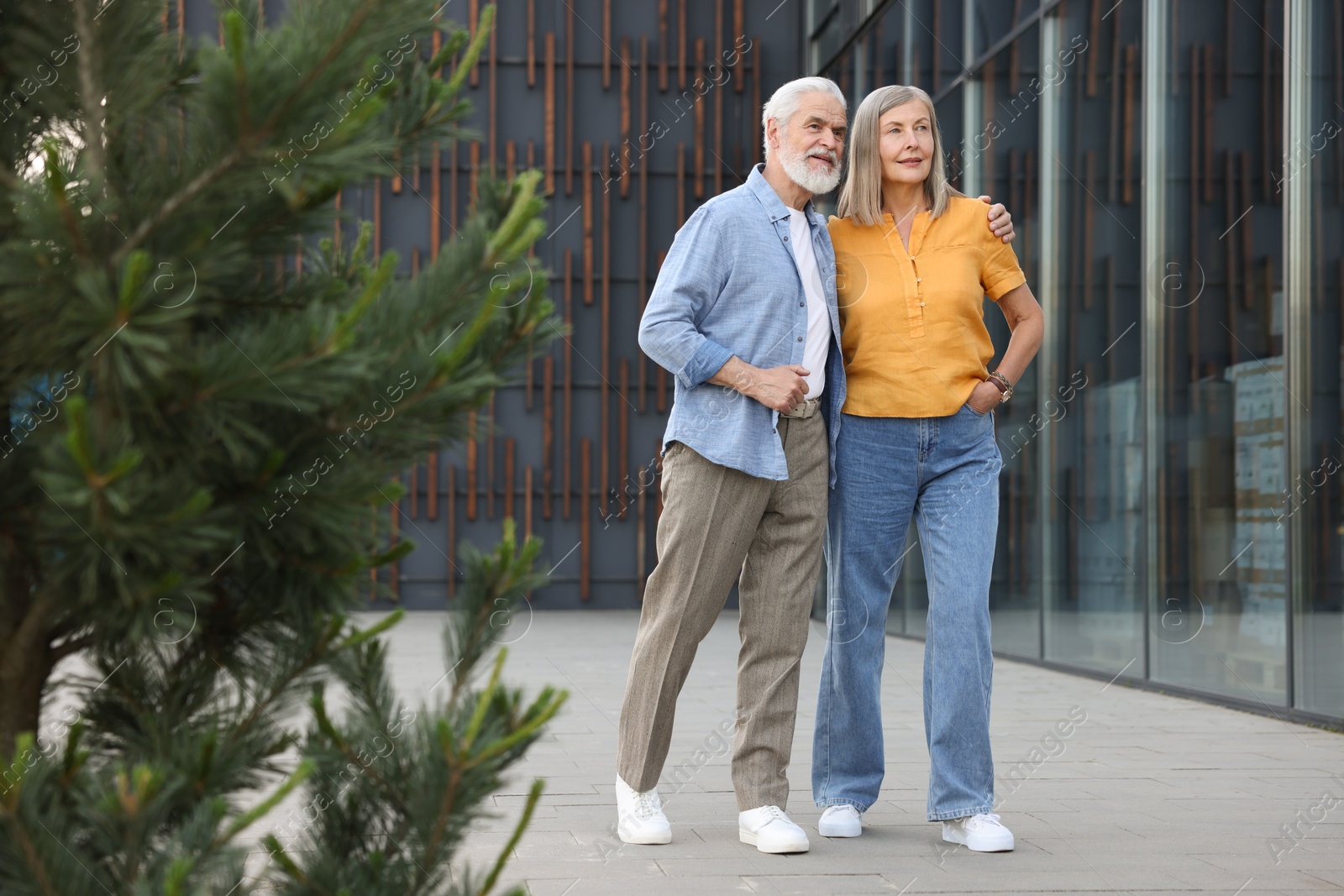 Lovely senior couple walking together near building outdoors Photo of Lovely senior couple walking together near building outdoors