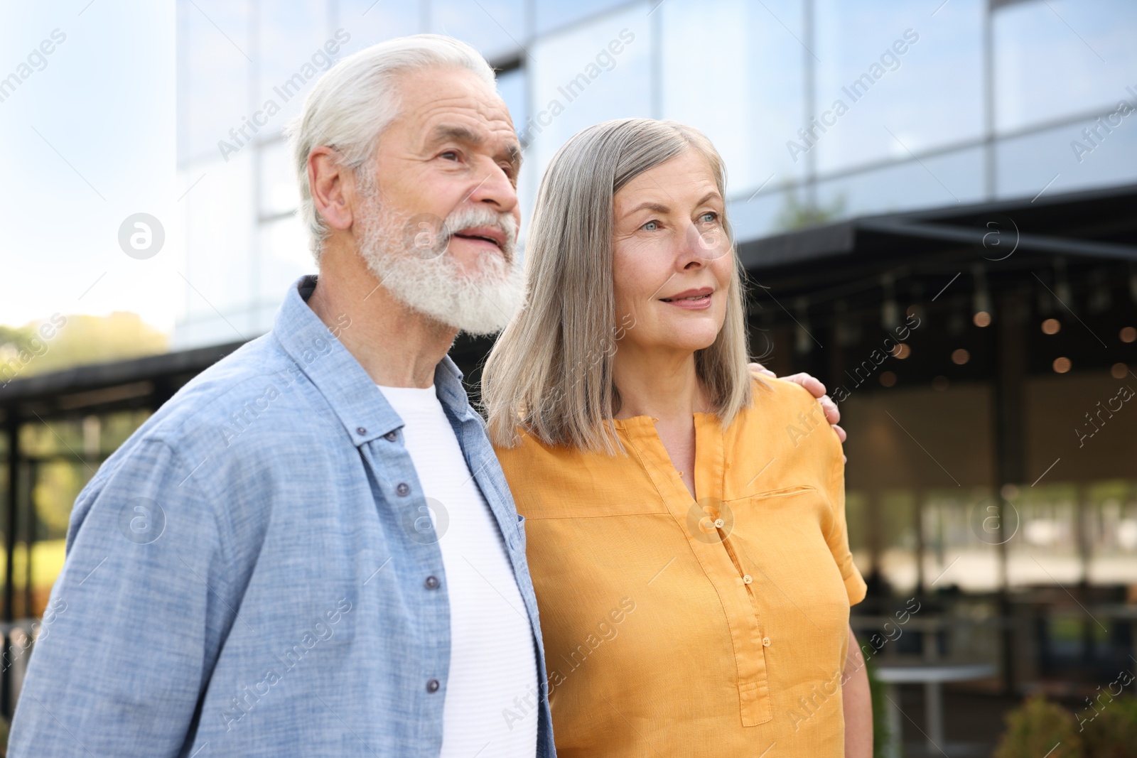 Lovely senior couple walking together near building outdoors Photo of Lovely senior couple walking together near building outdoors