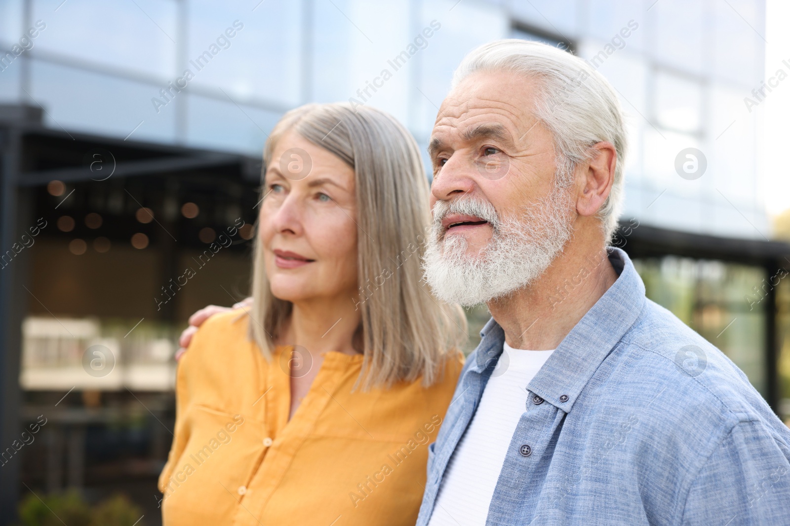 Lovely senior couple walking together near building outdoors Photo of Lovely senior couple walking together near building outdoors