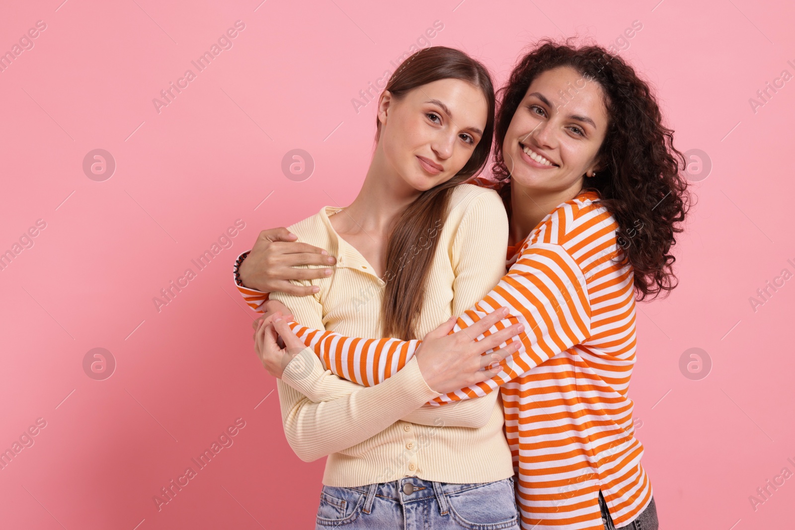 Two happy friends hugging on pink background, space for text Photo of Two happy friends hugging on pink background, space for text