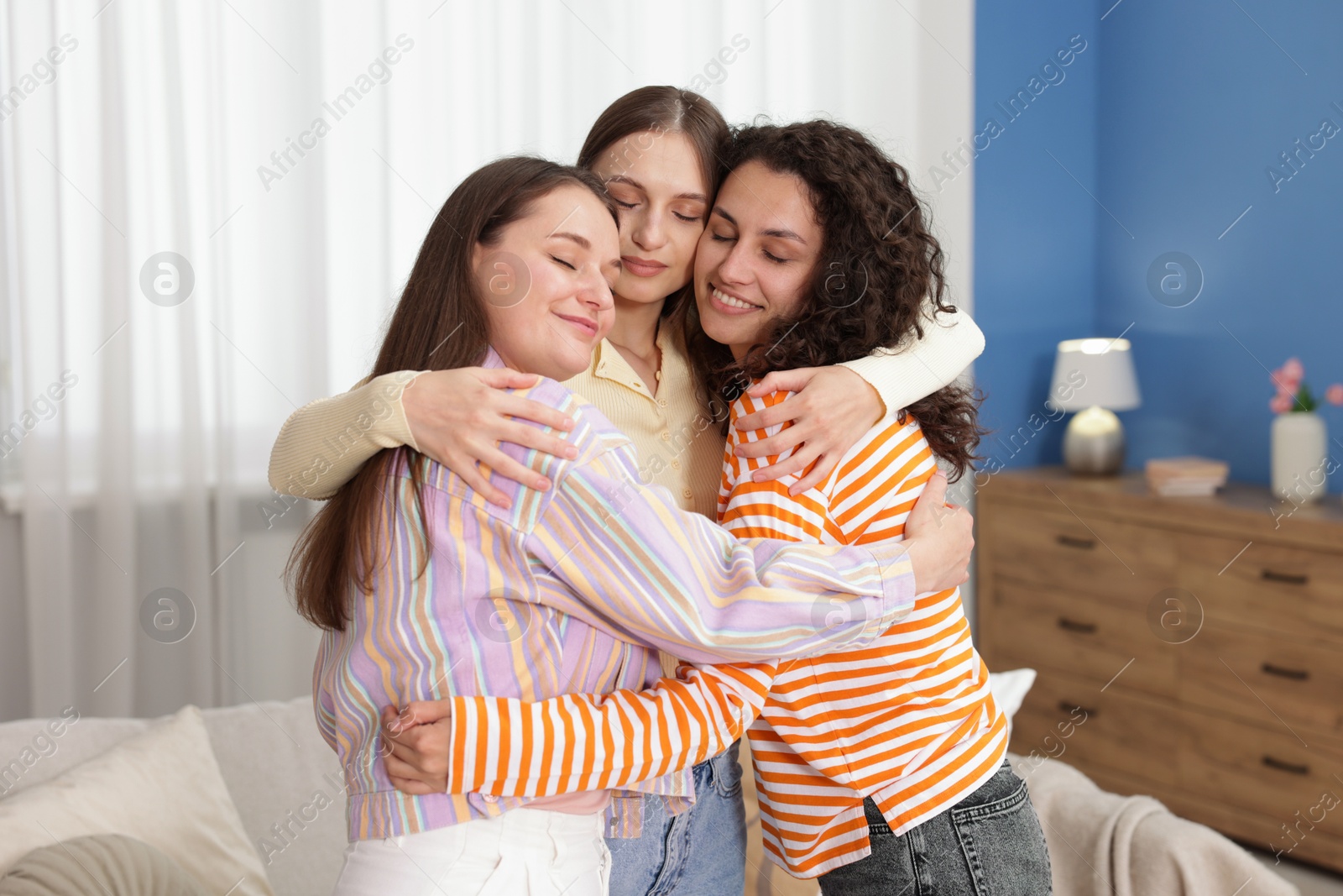 Three friends hugging each other at home Photo of Three friends hugging each other at home