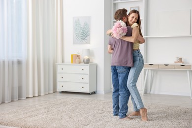 Photo of Happy young couple dancing together at home. Space for text