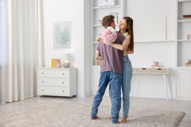 Photo of Young couple dancing together at home. Space for text