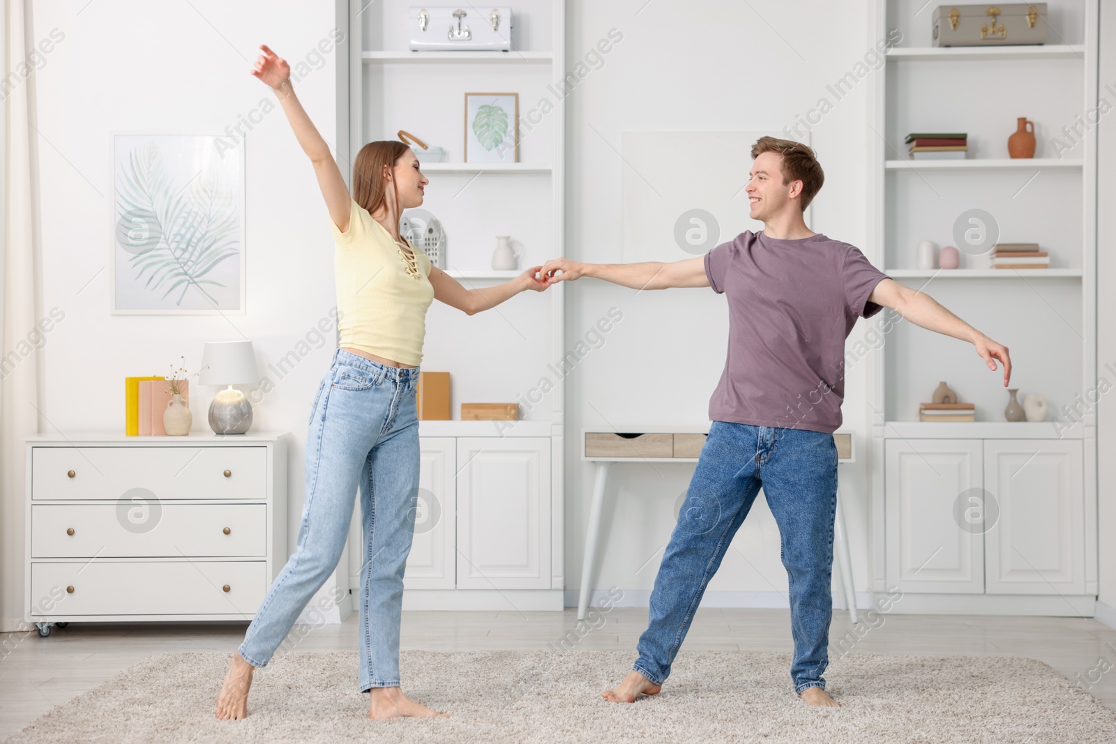 Happy young couple dancing together at home Photo of Happy young couple dancing together at home