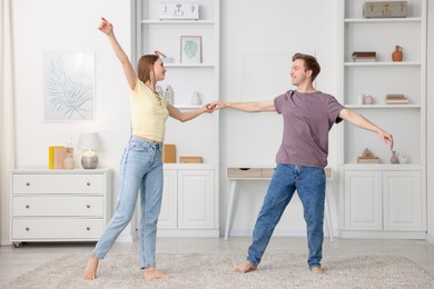 Photo of Happy young couple dancing together at home