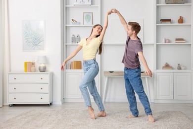 Photo of Happy young couple dancing together at home