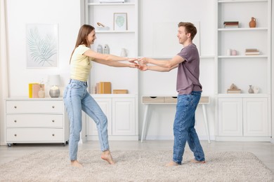 Photo of Happy young couple dancing together at home