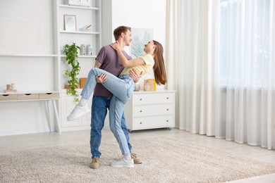 Photo of Happy young couple dancing together at home