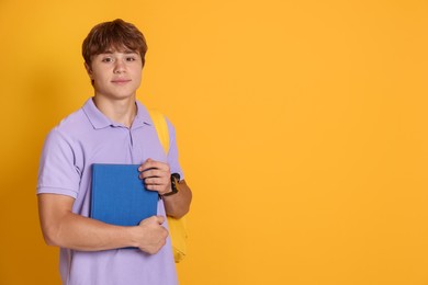 Photo of Cute teenage with book on yellow background. Space for text