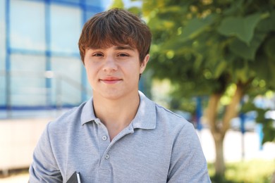 Photo of Portrait of cute teenage boy on city street