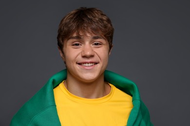 Photo of Portrait of smiling teenage boy on grey background