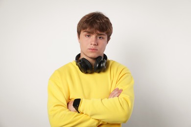 Photo of Portrait of teenage boy with crossed arms on light grey background