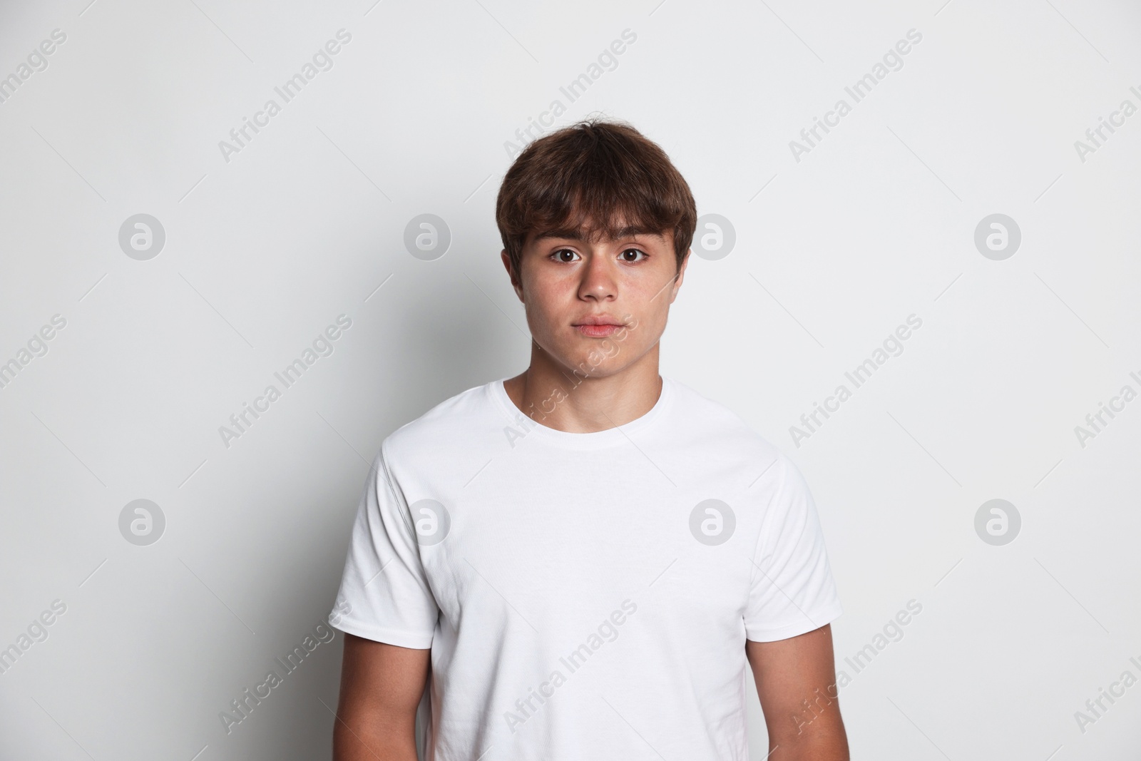 Portrait of cute teenage boy on light grey background Photo of Portrait of cute teenage boy on light grey background