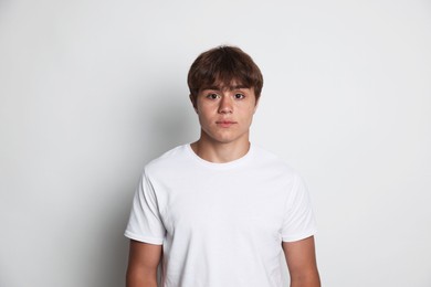Photo of Portrait of cute teenage boy on light grey background