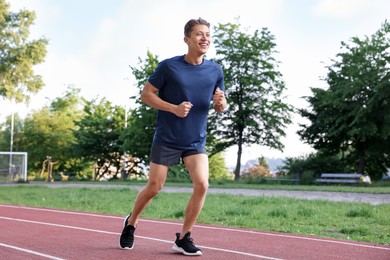Photo of Sporty man running at stadium. Healthy lifestyle