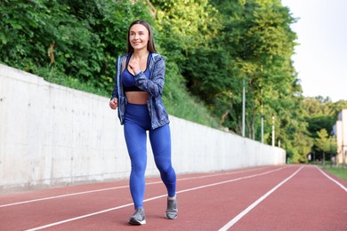 Photo of Sporty woman running at stadium, space for text