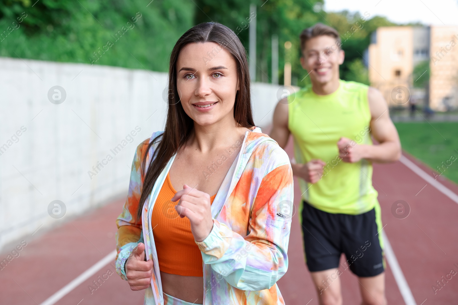 Sporty couple running at stadium, selective focus Photo of Sporty couple running at stadium, selective focus