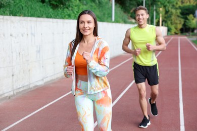 Photo of Sporty couple running at stadium. Healthy lifestyle