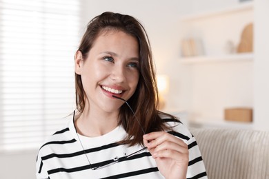 Photo of Smiling teenage girl with glasses at home