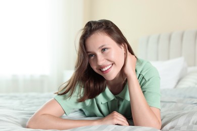 Photo of Portrait of smiling teenage girl on bed at home