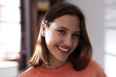 Photo of Portrait of smiling teenage girl at home, closeup