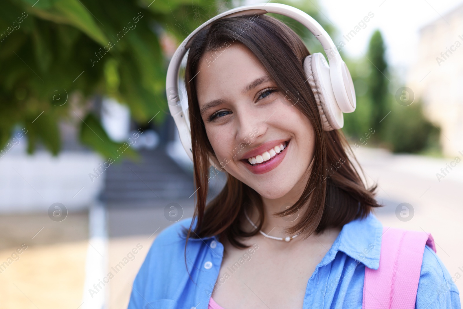 Portrait of smiling teenage girl in headphones outdoors Photo of Portrait of smiling teenage girl in headphones outdoors