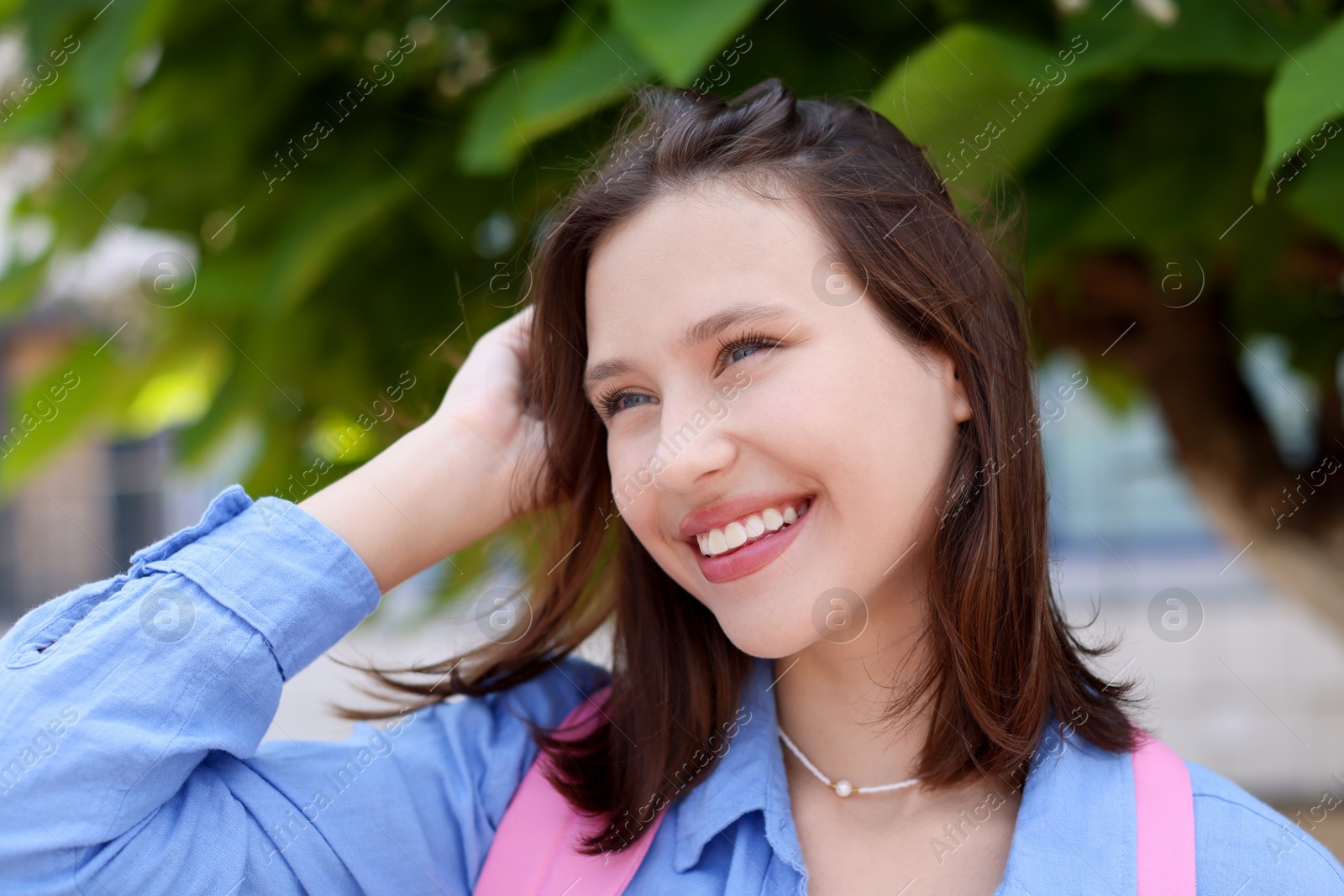 Portrait of smiling teenage girl on city street Photo of Portrait of smiling teenage girl on city street