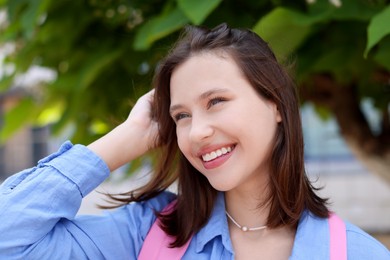 Photo of Portrait of smiling teenage girl on city street