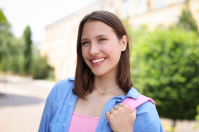 Photo of Portrait of smiling teenage girl on city street