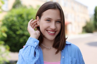 Photo of Portrait of smiling teenage girl on city street