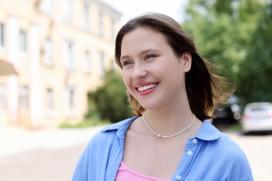 Photo of Portrait of smiling teenage girl on city street