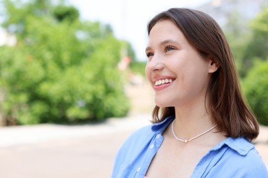Photo of Smiling teenage girl on city street. Space for text