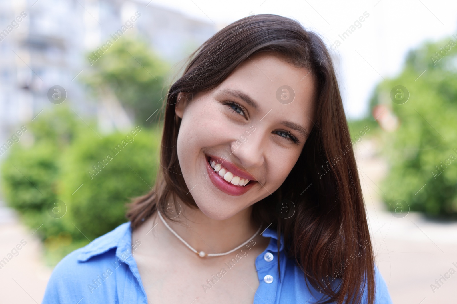 Portrait of smiling teenage girl on city street Photo of Portrait of smiling teenage girl on city street