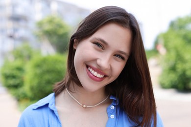 Photo of Portrait of smiling teenage girl on city street