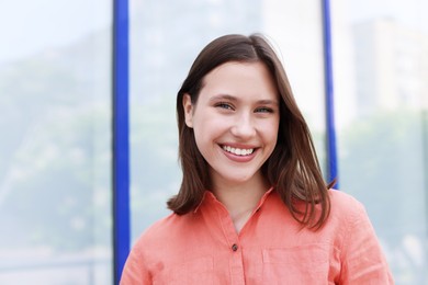 Photo of Portrait of smiling teenage girl near building outdoors