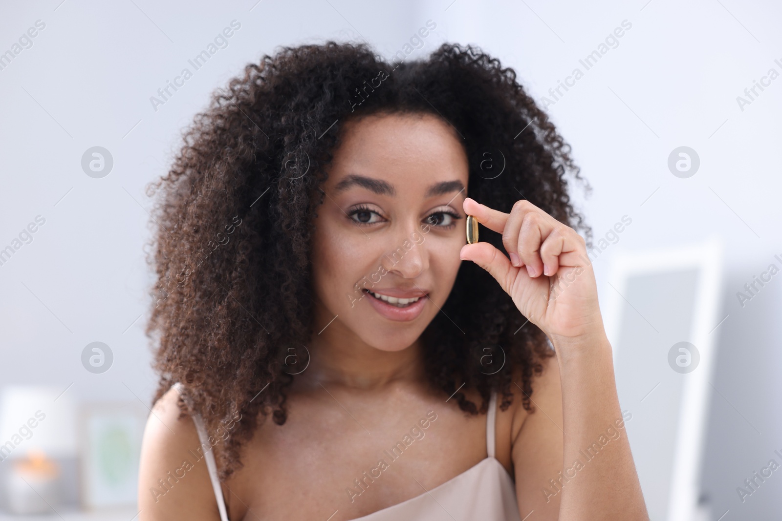 Beautiful Brazilian woman with collagen pill indoors Photo of Beautiful Brazilian woman with collagen pill indoors
