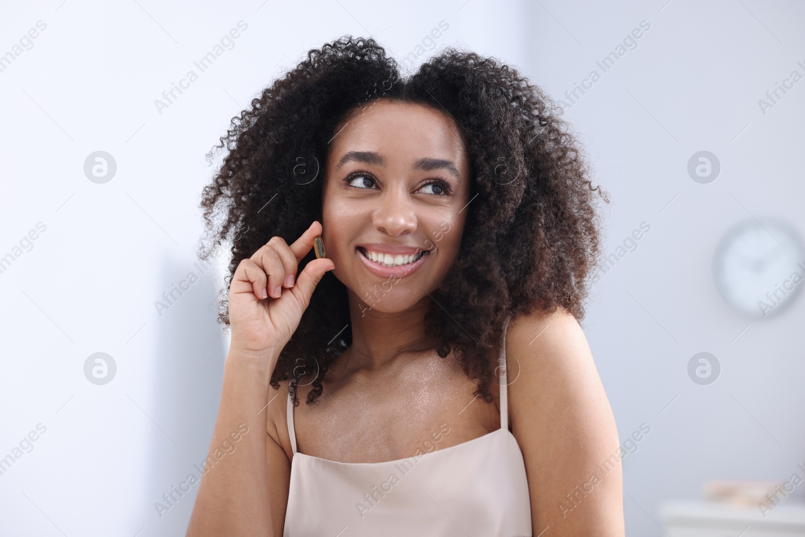 Beautiful Brazilian woman with collagen pill indoors Photo of Beautiful Brazilian woman with collagen pill indoors