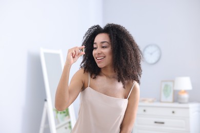 Photo of Beautiful Brazilian woman with collagen pill indoors